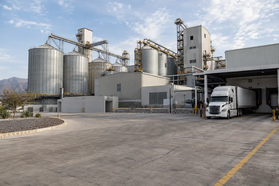 Silos y camión de carga en un complejo industrial