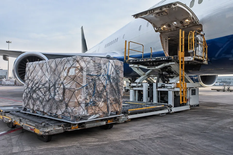 Carga aérea embalada junto a una plataforma de servicio aeroportuaria