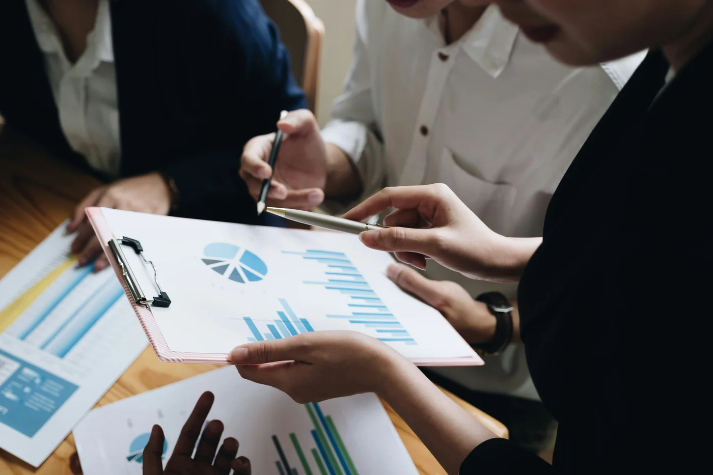 Equipo de trabajo revisando gráficas y documentación financiera