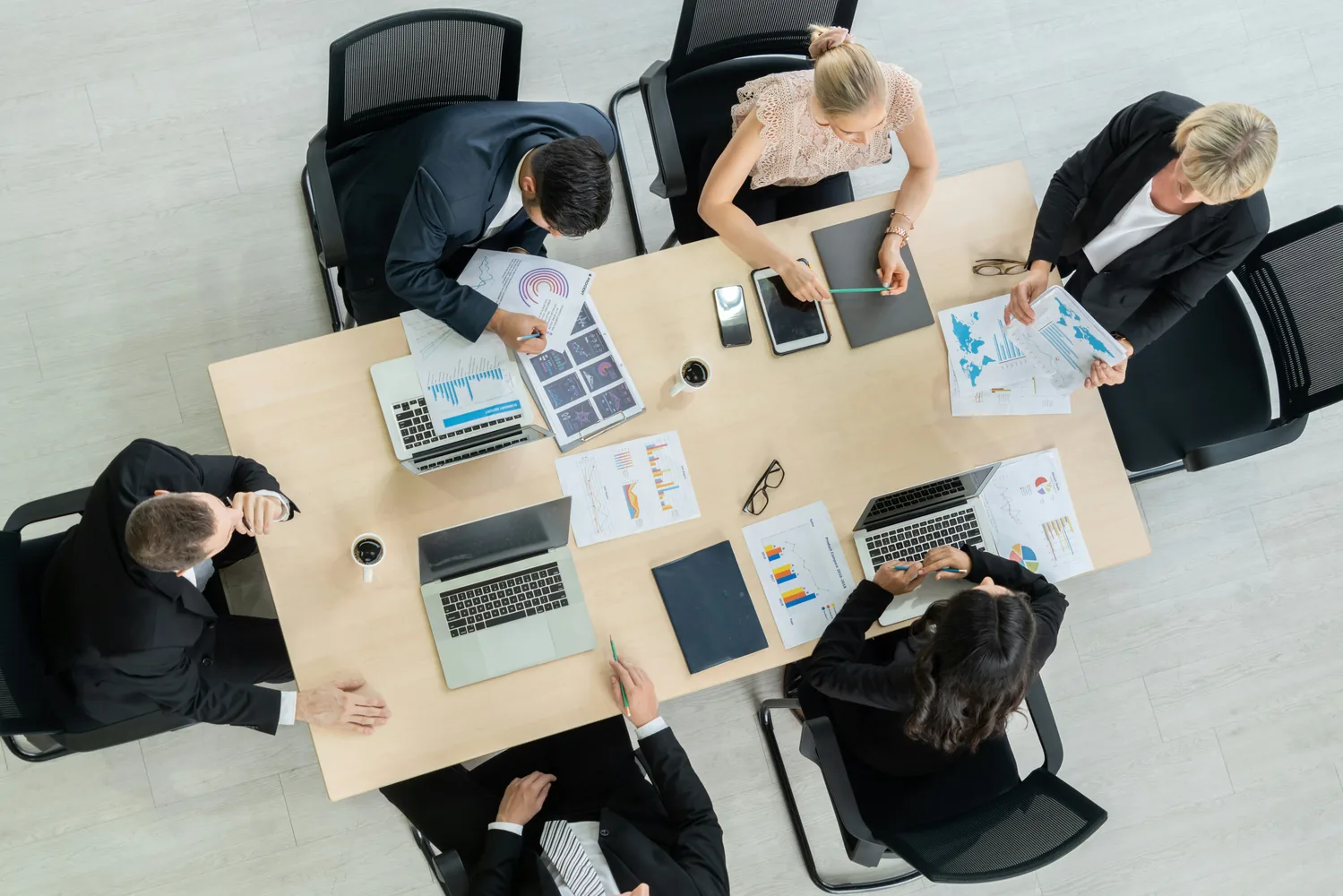 Análisis conjunto de información financiera en una mesa de trabajo; fotografía ilustrativa