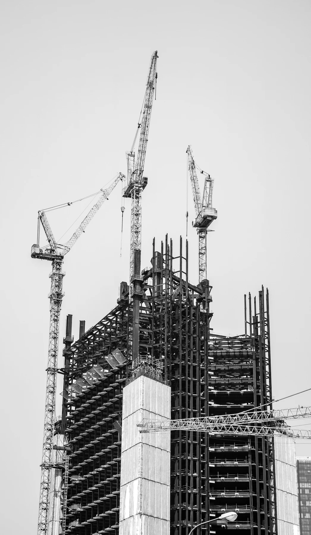 Edificio en construcción con grúa, en blanco y negro