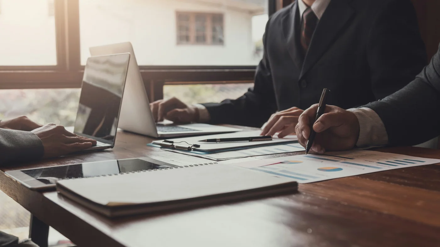 Profesional revisando documentos financieros en una mesa de trabajo