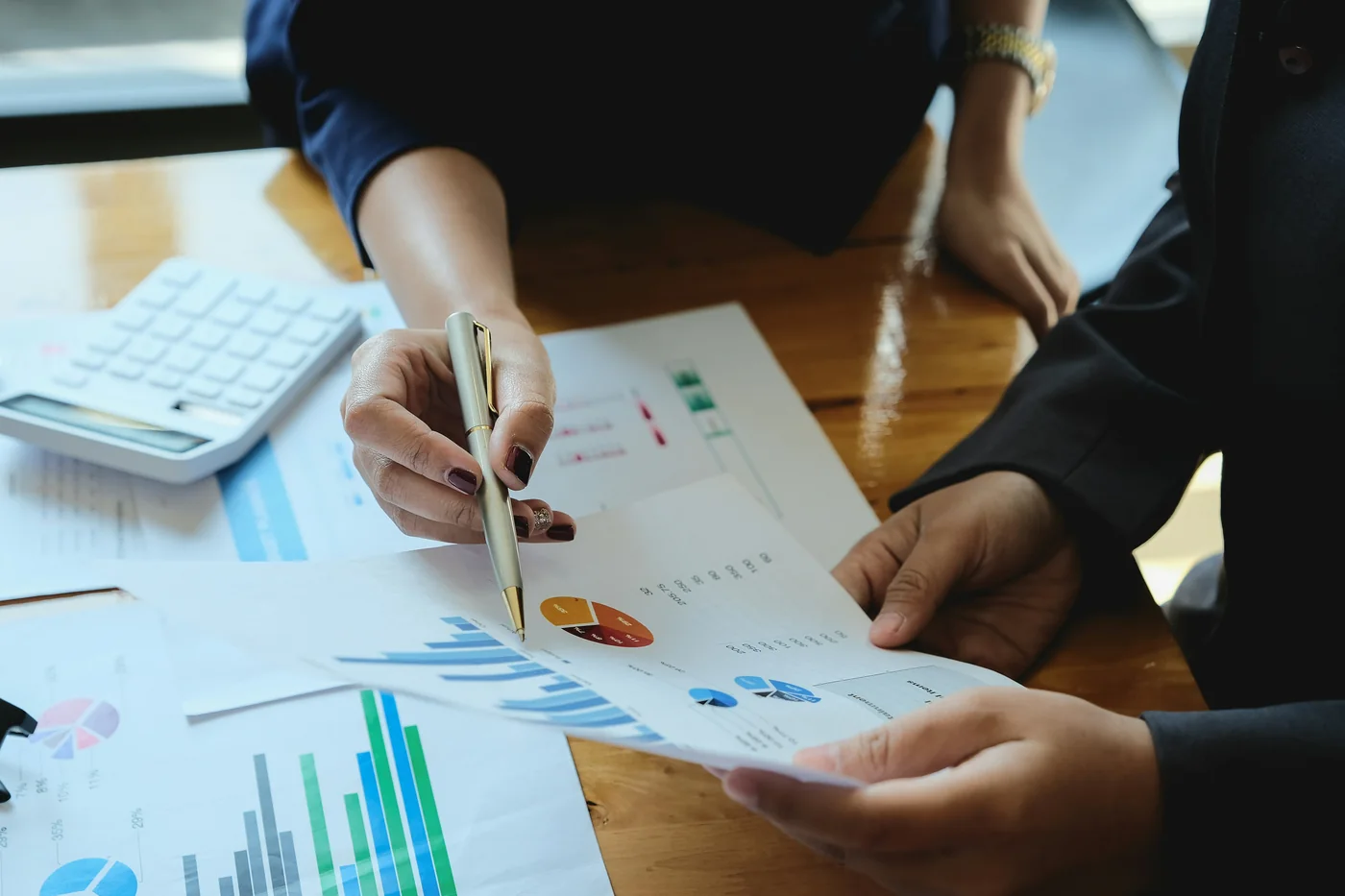 Análisis de gráficas financieras y cálculos sobre una mesa
